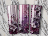 Three tumblers with floral and butterfly designs on a marble background.