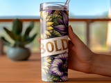 Tumbler with bold floral pattern held by a hand.