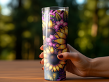Hand holding a tall tumbler with a vibrant floral and sunflower pattern.