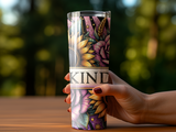 Tumbler with floral pattern and "KIND" text, held by hand.