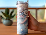 Denim-patterned tumbler with floral and pearl embellishments, held by a hand.