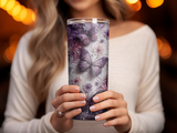 Woman holding a tall tumbler with a purple butterfly and floral pattern.
