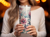 Woman holding a floral and butterfly patterned tumbler.