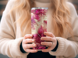 Pink butterfly tumbler with ornate floral pattern held by person wearing cream sweater.