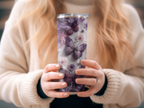 Purple butterfly floral patterned tumbler held by hands.