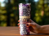 Hand holding a tumbler with floral pattern and "GLOW" text.