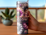 Tumbler with sunflowers and the word "GLOW" against a speckled background.
