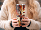 Woman holding a patterned tumbler with floral and swirling designs.