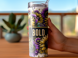 Tumbler with bold sunflowers and floral design held by a hand.