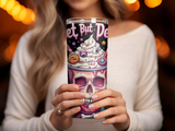 Tumbler with a skull topped with colorful candy and frosting.
