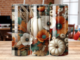 White pumpkins, orange poppies, and wheat stalks on a plaid background.
