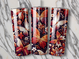 Three tumblers with a shimmering butterfly and floral pattern on a marble surface.