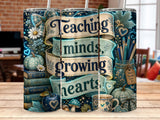 Ribbon banner with "Teaching minds growing hearts" over books, pumpkins, and mug.
