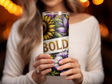Woman holding a tumbler with sunflowers and bold text.
