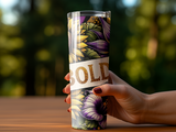Tumbler with floral pattern and "BOLD" text held by a person's hand.