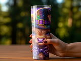 Purple wizard hat and bow tie adorned Highland cow on tumbler held by hand.