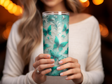 Glass tumbler with teal butterflies and glitter pattern.