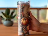 Tumbler with autumn theme, featuring pumpkins, leaves, acorns, and a hat.