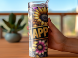 Tumbler with sunflowers, flowers, and "Happy" text held by hand.