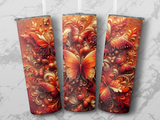 Three tumblers with ornate butterfly and floral designs in warm, sparkling colors.