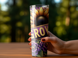 Tall tumbler with sunflowers and text "GROW" held by a hand.