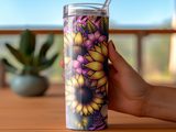 Hand holding a colorful tumbler with sunflowers and floral patterns.