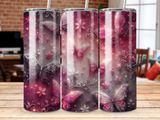 Tumbler with ornate pink butterflies and floral designs against a dark background.
