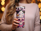 Pink tumbler with skull and candy design, held by a woman.