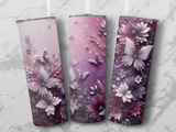 Three tumblers with butterfly and floral designs on a marbled background.