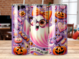 Pink and white ghost wearing glasses, surrounded by Halloween candy and pumpkins.