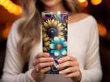Woman holding a tumbler with sunflowers and teal flowers.