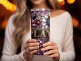 Woman holding a tumbler with floral and "PLAY" text design.