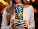 Woman holding a floral tumbler with the word "LOVE" in a golden rectangle.