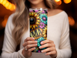 Woman holds tumbler with floral design and "Mama" text.