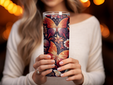 Woman holding a tumbler with a butterfly and floral pattern.