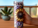 Sunflower and floral design on a clear tumbler held by a hand.