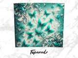 Green and teal butterflies on an ornate swirling floral background.
