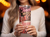 Woman holding a tumbler with "Teach, Mod, Of, Summer" text and a straw.