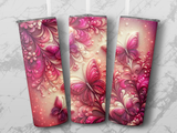 Three tumblers with pink butterfly and floral designs on a marble background.