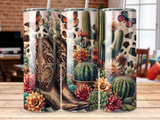 Cowboy boot surrounded by cacti, succulents, and butterflies on cow print background.