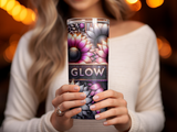 Woman holding a tumbler with a floral "Glow" design.