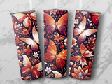 Three tumblers with ornate, shimmering butterfly and floral designs.