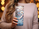 Tumbler with pearl and floral embellishments on denim-texture background.